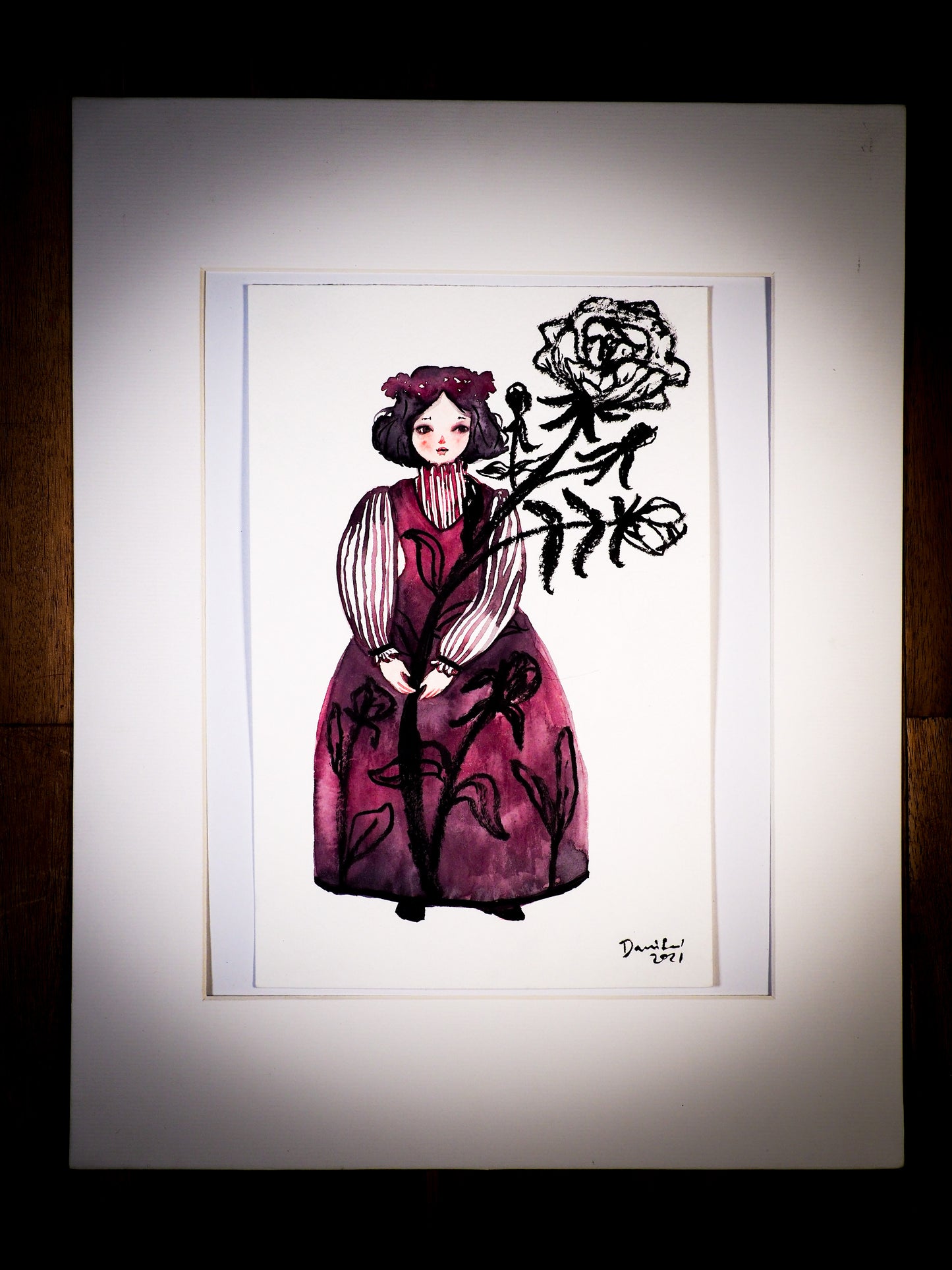 An original mixed media watercolor by Idania Salcido, the artist behind Danita Art.  This is a beautiful watercolor painting, A girl wearing a crimson red dress with a huge black ink and watercolor rose flower in her hands. Painted with watercolors over watercolor paper.