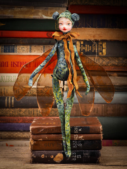 Each doll by Idania Salcido, the artist behind Danita Art is made with hand dyed fabric that I prepare myself, adorned with a lush set of mica wings and a silky ribbon, she is a beautiful dragonfly ready to take flight.  Approximately 12 Inches tall. Original art doll in hand dyed fabric with natural pigments, polymer clay face and mixed media applications.