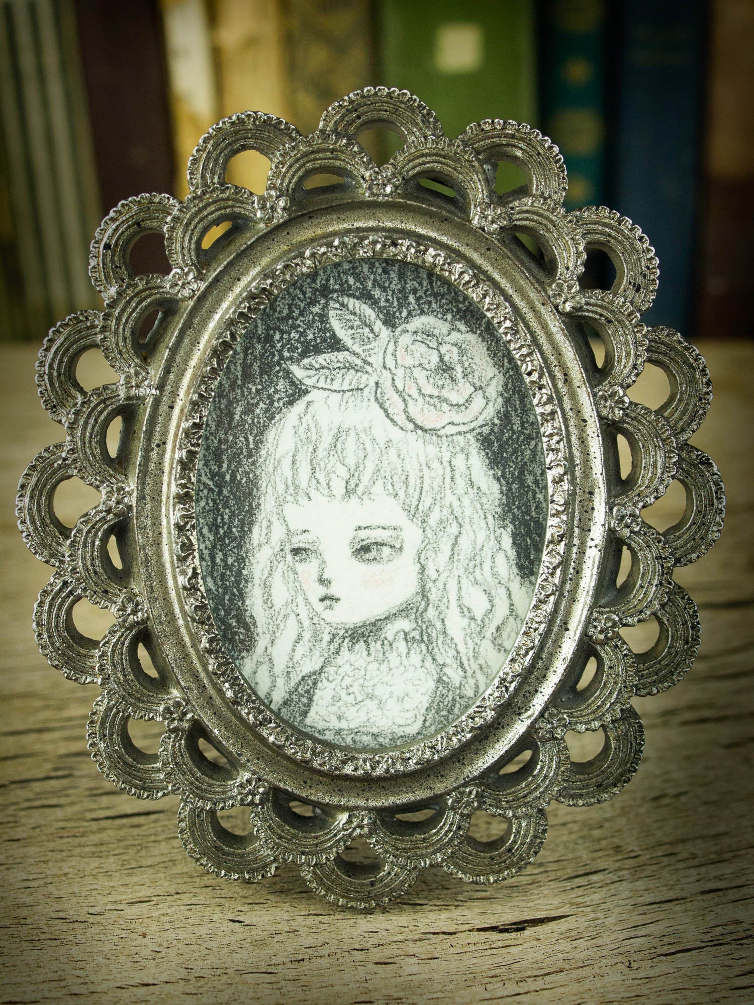 This is a very simple drawing in pencil by Danita Art, with just a little bit of rouge red on her cheeks. I love the vintage style of the image, and the little frame that comes with it it's just perfect for her.