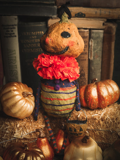 This adorable Halloween handmade ornament pumpkin jack-o-lantern doll monster by Idania Salcido, the artist behind Danita Art, is made with painted spun cotton and paper. It has hand painted face, teeth and eyes with a glittery paper had and matching paper costume. A Halloween home decoration on trick-or-treat night.