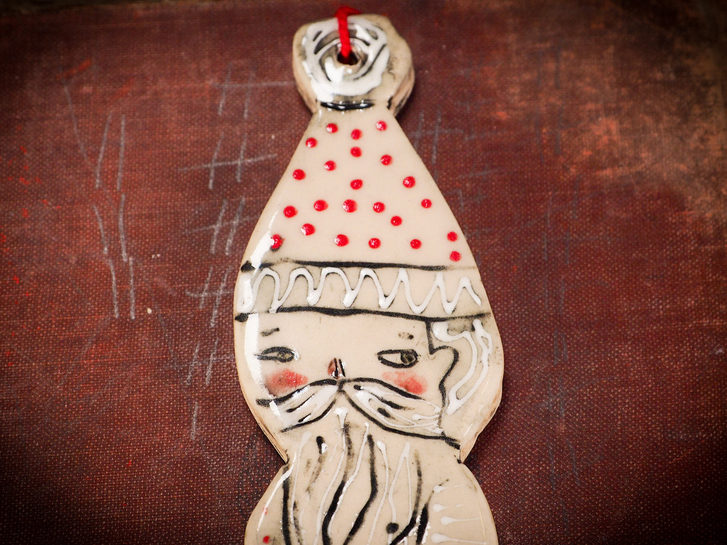 An original Christmas Holiday tree round glazed ceramic ornament handmade by Idania Salcido, the artist behind Danita Art. Glazed carved sgraffito stoneware, hand painted and decorated, it is illustrated by hand with snowmen, Christmas trees, Santa Claus, angels and snow balls and winter themes.