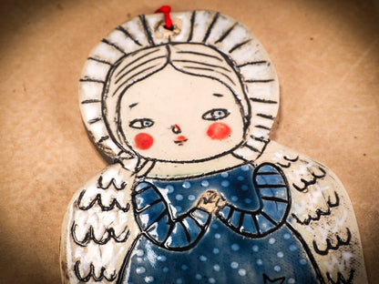 An original Christmas Holiday tree round glazed ceramic ornament handmade by Idania Salcido, the artist behind Danita Art. Glazed carved sgraffito stoneware, hand painted and decorated, it is illustrated by hand with winter scenes with snowmen, Christmas trees, Santa Claus, angels and snow balls and winter themes.