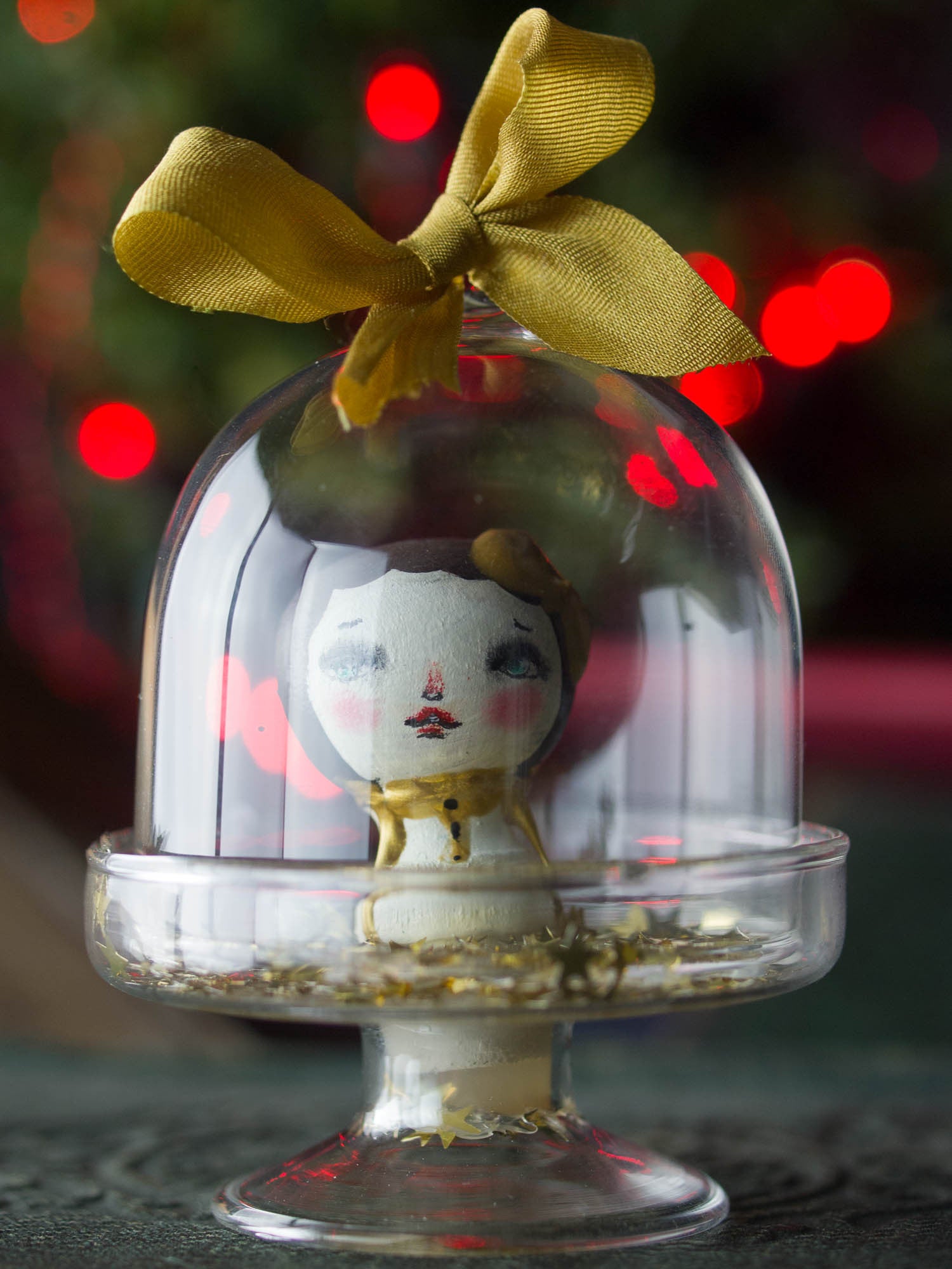 A mini kokeshi wooden art doll handmade by Danita Art, encased in a little glass dome for your Christmas tree.