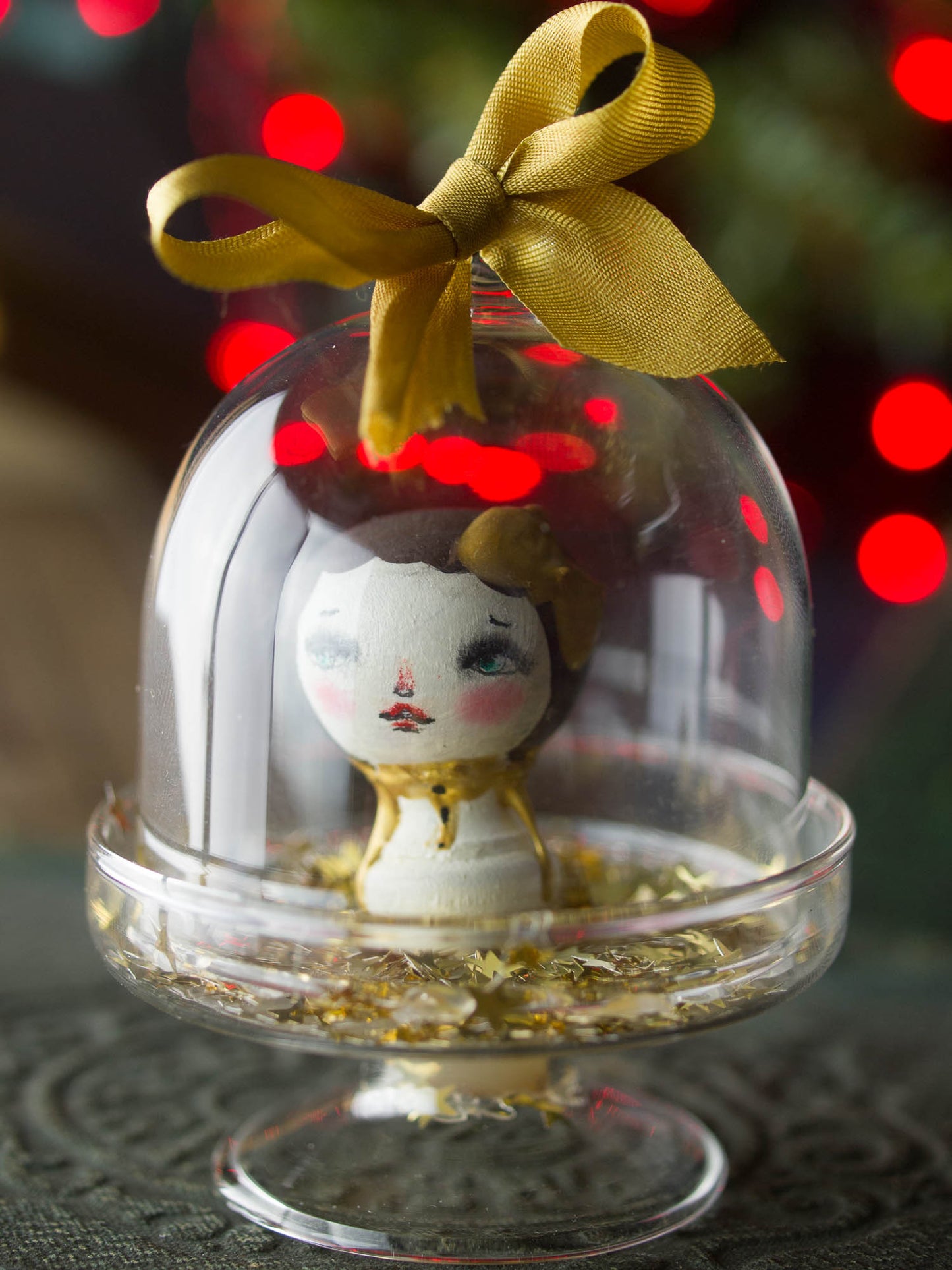 A mini kokeshi wooden art doll handmade by Danita Art, encased in a little glass dome for your Christmas tree.