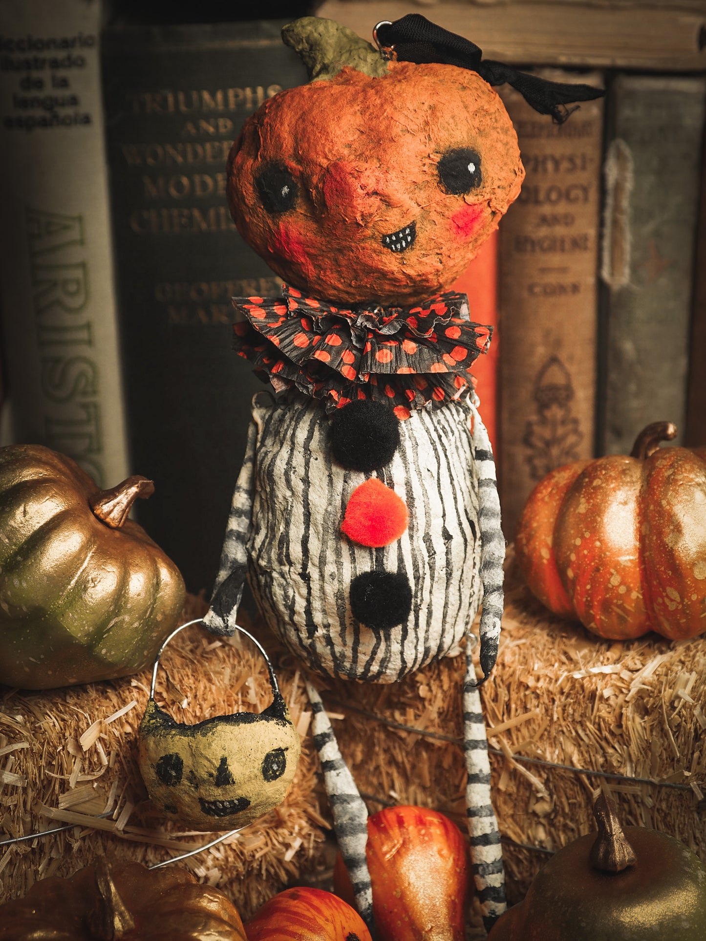 This adorable Halloween handmade ornament pumpkin jack-o-lantern doll monster by Idania Salcido, the artist behind Danita Art, is made with painted spun cotton and paper. It has hand painted face, teeth and eyes with a glittery paper had and matching paper costume. A Halloween home decoration on trick-or-treat night.