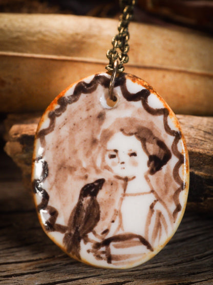 Unique fired ceramic porcelain necklace oval Frida Kahlo pendant by mixed media artist Danita Art. Each jewelry setting is hand drawn and illustrated by the artist in her art studio, perfect for any dressing style. A casual gathering with friends or a fancy formal dinner, this necklace is a perfect fashion accessory.