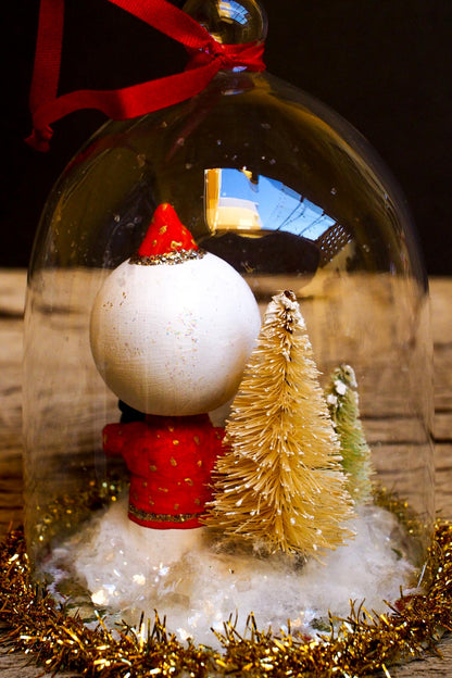 An original handmade christmas tree ornament by Idania Salcido. A clear domed diorama with a holiday scene with Santa Claus elves, Christmas Trees, Elves, Gifts and magical glitter deer. Perfect to decorate your Christmas Tree, your mantelpiece or to be used as accents on a dinner table.