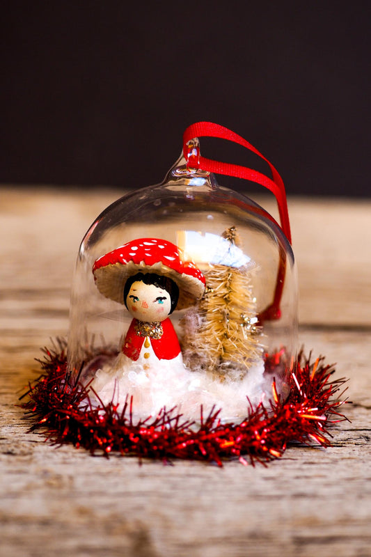 An original handmade christmas tree ornament by Idania Salcido. A clear domed diorama with a holiday scene with Santa Claus elves, Christmas Trees, Elves, Gifts and magical glitter deer. Perfect to decorate your Christmas Tree, your mantelpiece or to be used as accents on a dinner table.
