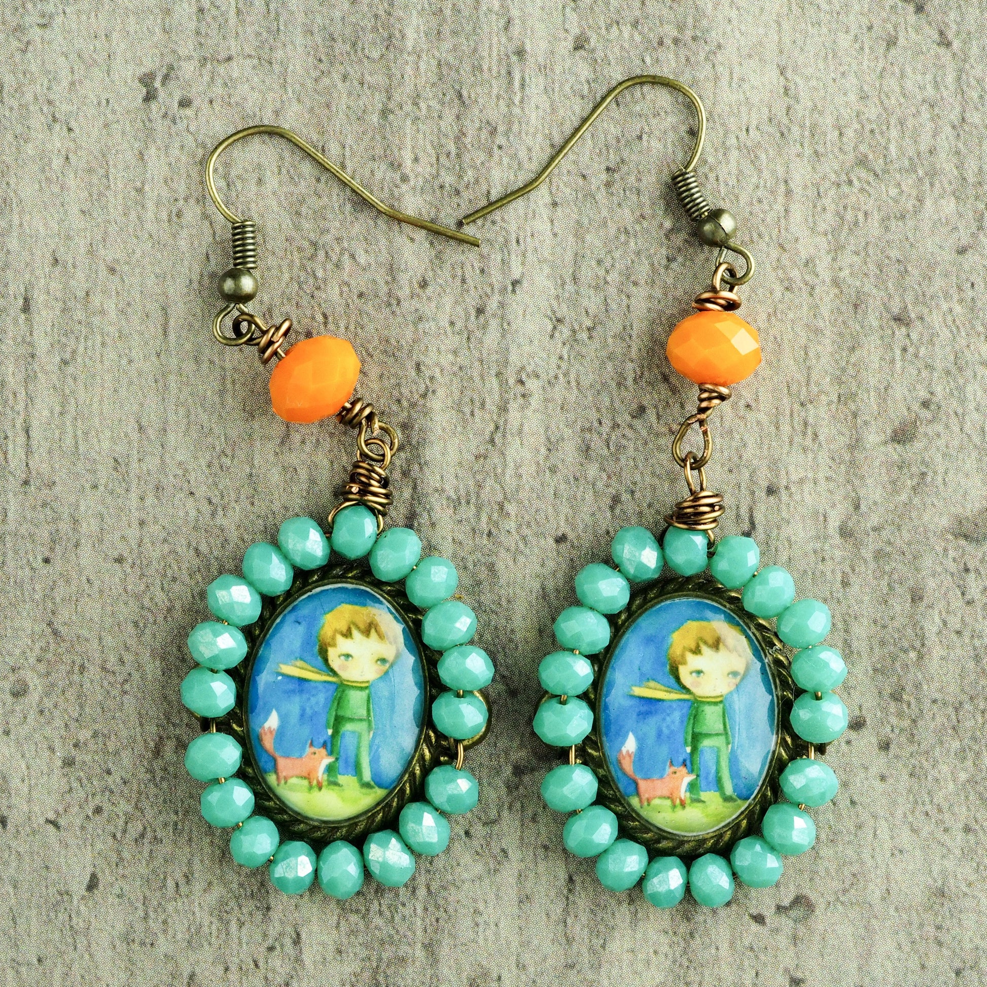 Original one of a kind earrings by Danita. The little prince is painted in the whimsical and surrreal style of Danita. One of a kind original accessories and wearable art.