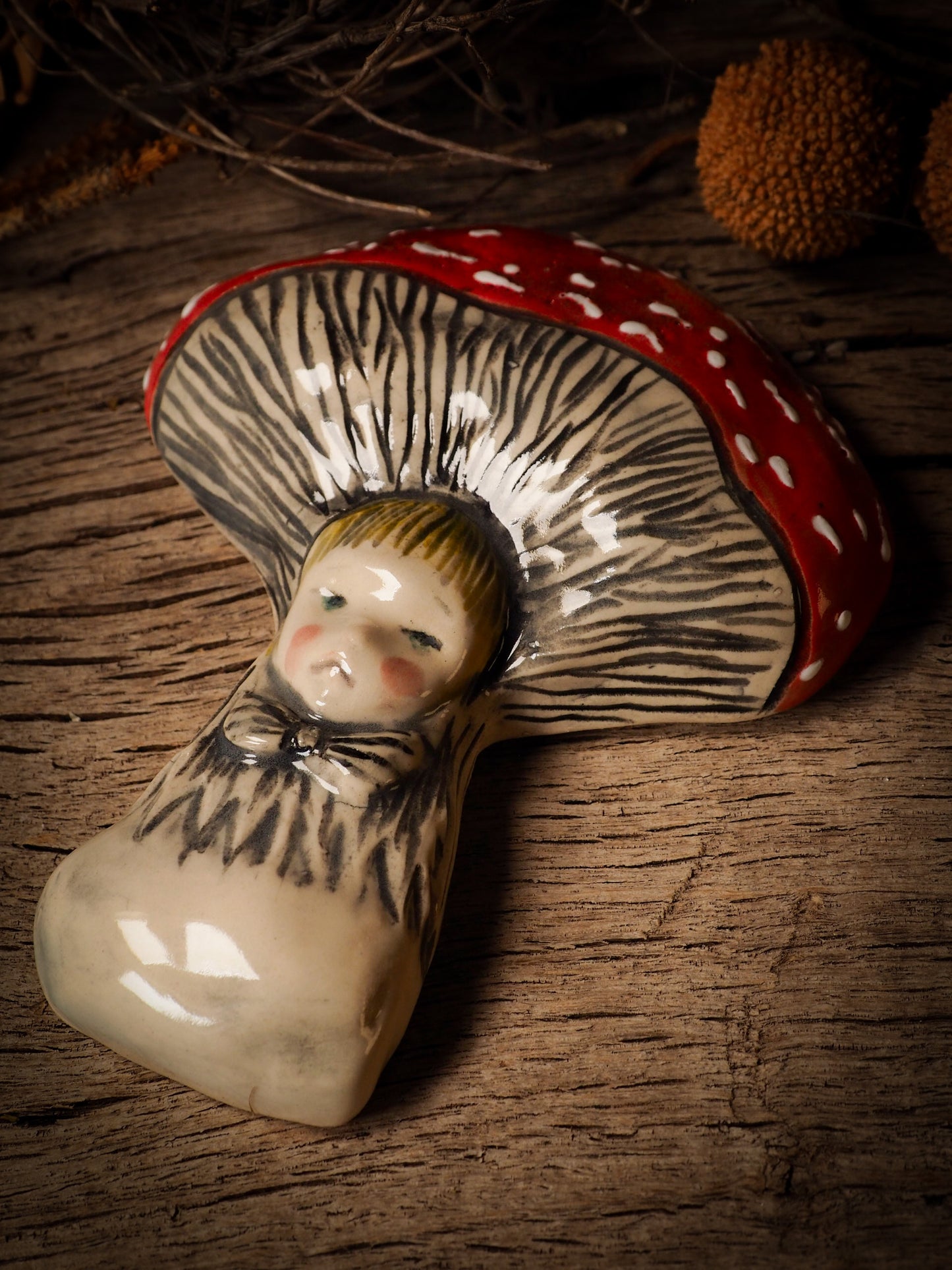 red toadstool mushroom fungi glazed ceramic torso figure inspired by Alice in Wonderland by Idania Salcido, the artist behind Danita Art. Lumps of clay hand sculpted and glazed are kiln fired. Beautiful fungi shaped wall hangings with nail hole in the back to place on wall with a hook or display on shelf or showcase.