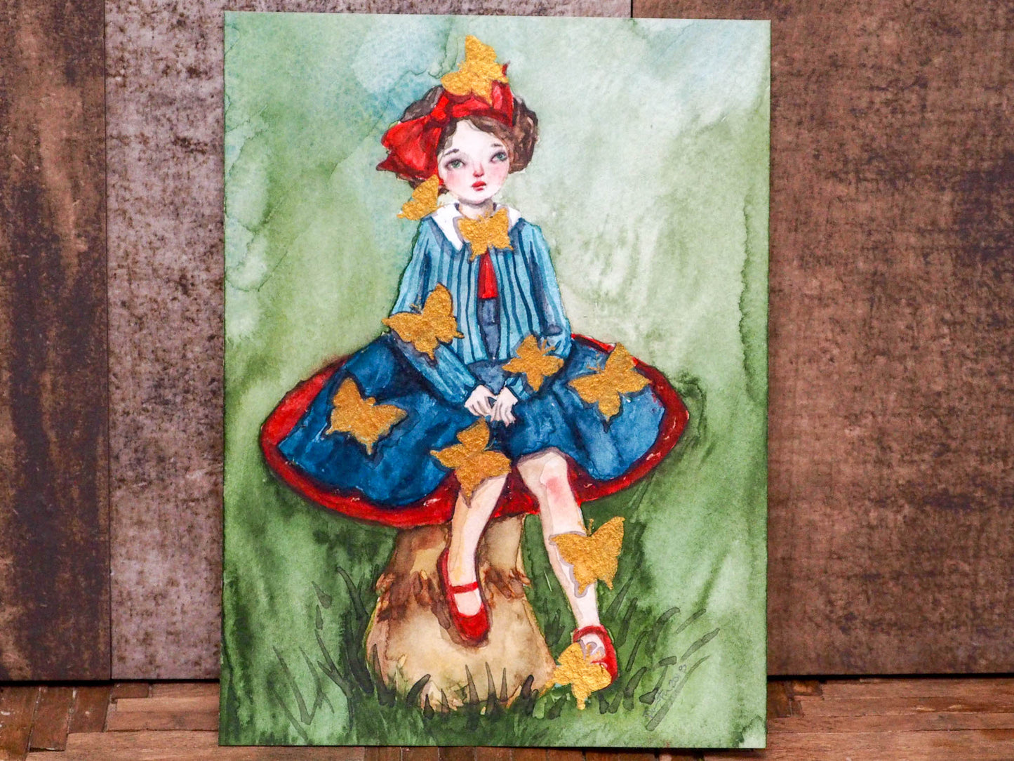 Danita painted herself sitting on a toadstool and surrounded by butterflies in this amazing watercolor original art by Danita. I painted them using a special golden painting I found on trip to Mexico, and they shimmer beautifully with the light!