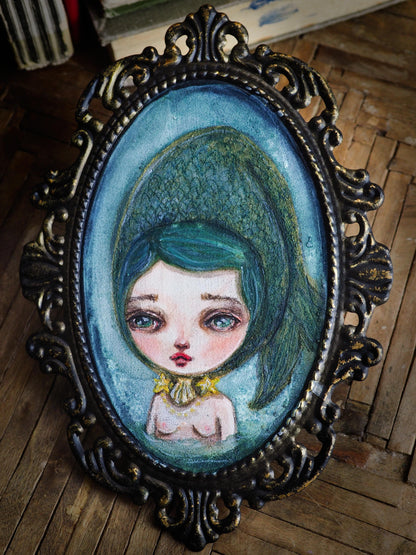 Danita painted a green mermaid with big eyes using watercolor paints.