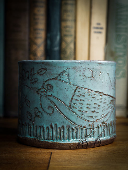 An original Idania Salcido Danita Art pinched ceramic cat pet food bowl. Handmade from locally foraged clay, this glazed ceramics one of a kind artwork is perfect for any kitchen plate and bowls unique collection. Thumbprints and  intentionally irregular shape give the bowl a cozy, warmly familiar feel when you pick it. It has a blue bird and flowers carved on the sides of this beautiful vase or bowl.