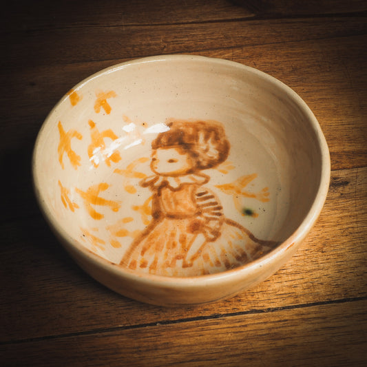An original Idania Salcido Danita Art ceramic cat pet food plate. Handmade from stoneware, this glazed ceramics one of a kind artwork is perfect for any kitchen plate and bowls unique collection. Thumbprints and  intentionally irregular shape give the bowl a cozy, warmly familiar feel when you pick it. A flock of yellow birds greets a beautiful girl in a striped dress, painted in watercolor style underglaze by Danita Art.