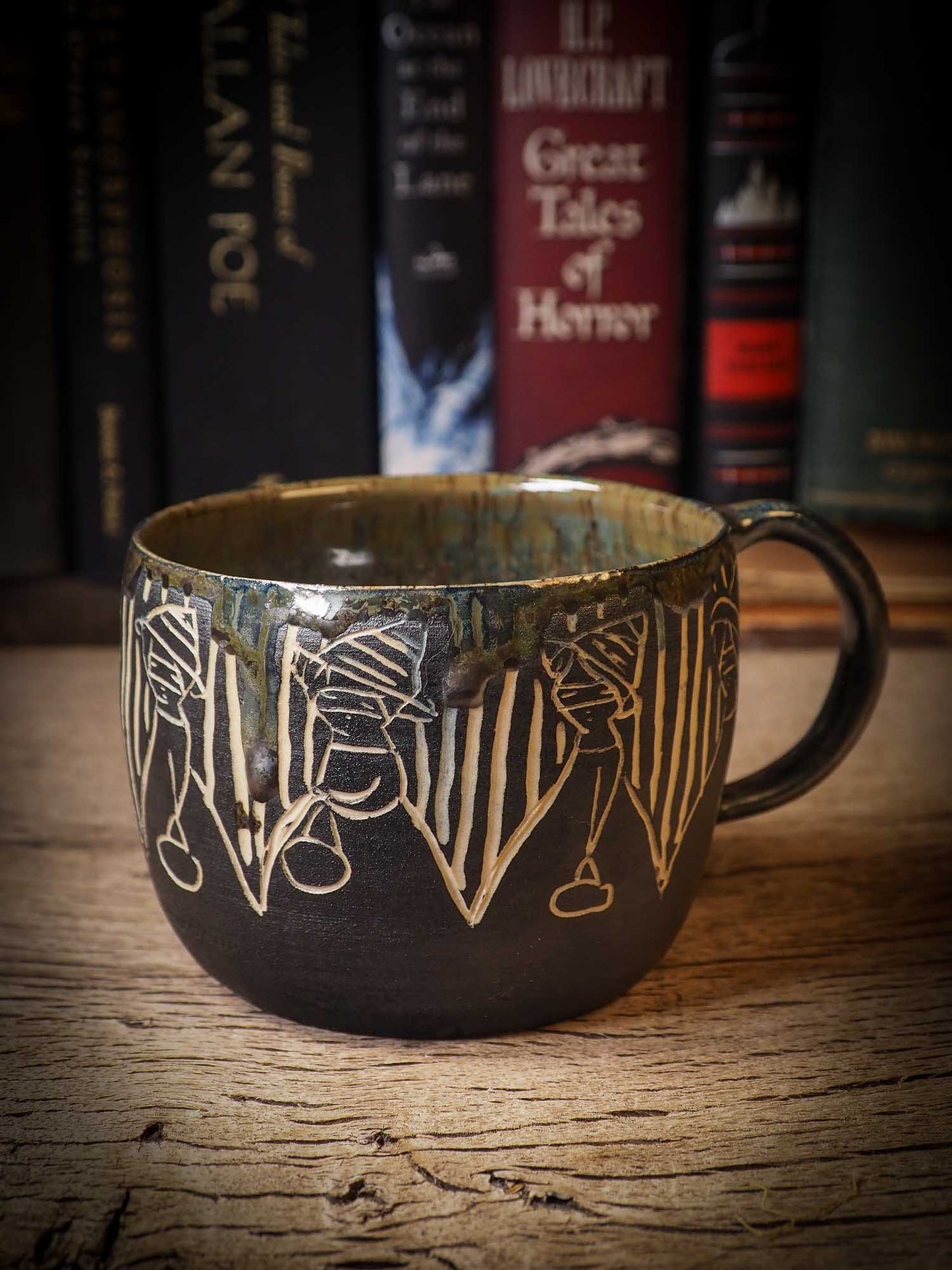 An original Halloween ceramic coffee mug bowl by Idania Salcido, the artist behind Danita Art. Made with wheel thrown clay, hand carved and glazed by the artist. The carved witches, ghosts, goblins and vampires give it a nice, folk art primitive feel to it. Perfect for Halloween Candy, ice cream and fruit and as pet cat bowl.