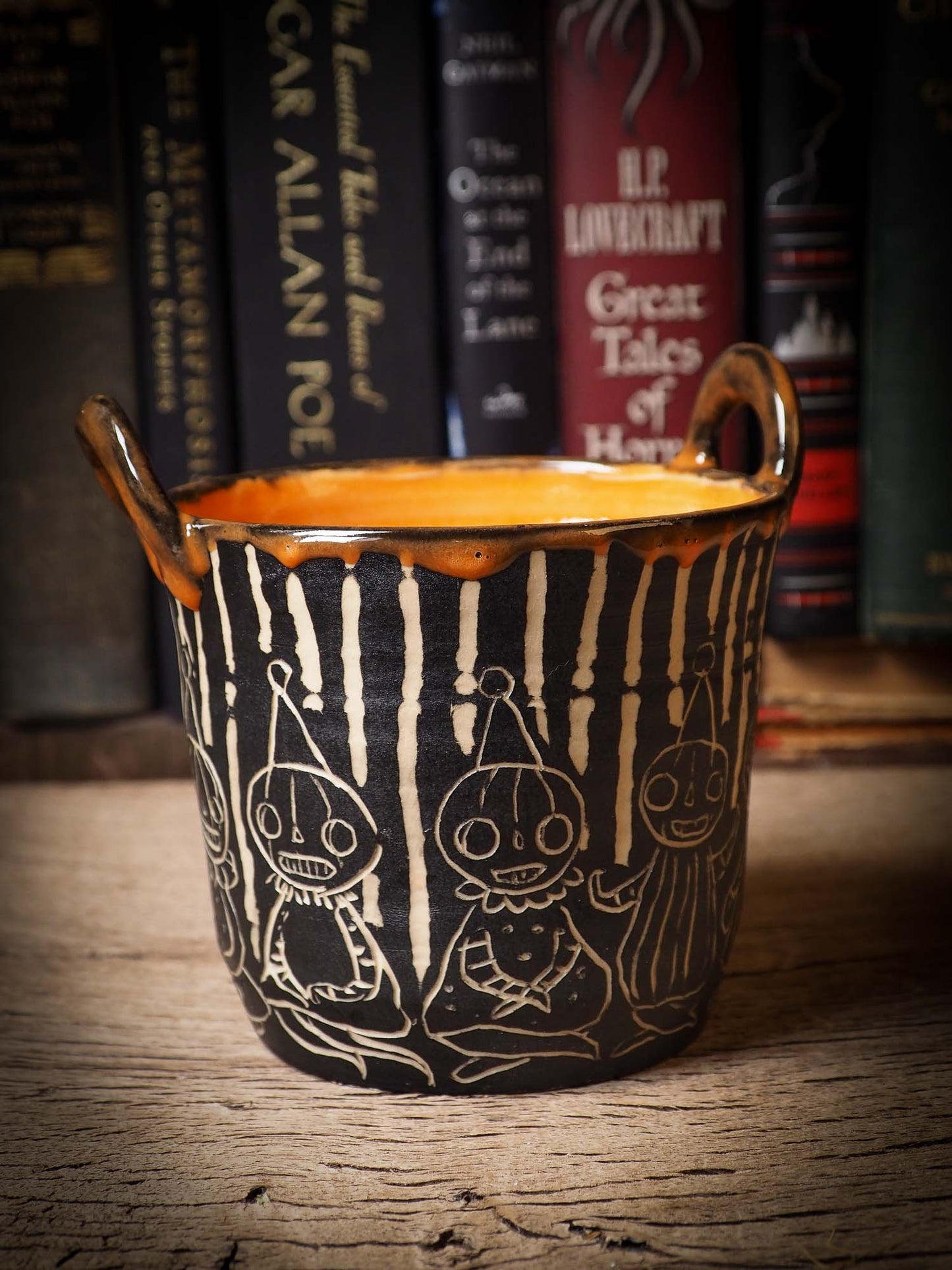 An original Halloween ceramic mug tumbler bowl handmade by Idania Salcido the artist behind Danita Art. Made with wheel thrown clay hand carved and glazed by the artist. Witches, ghosts, goblins and vampires give it a nice, folk art primitive feel to it. Perfect for Halloween Candy, ice cream and fruit, a pet cat bowl.