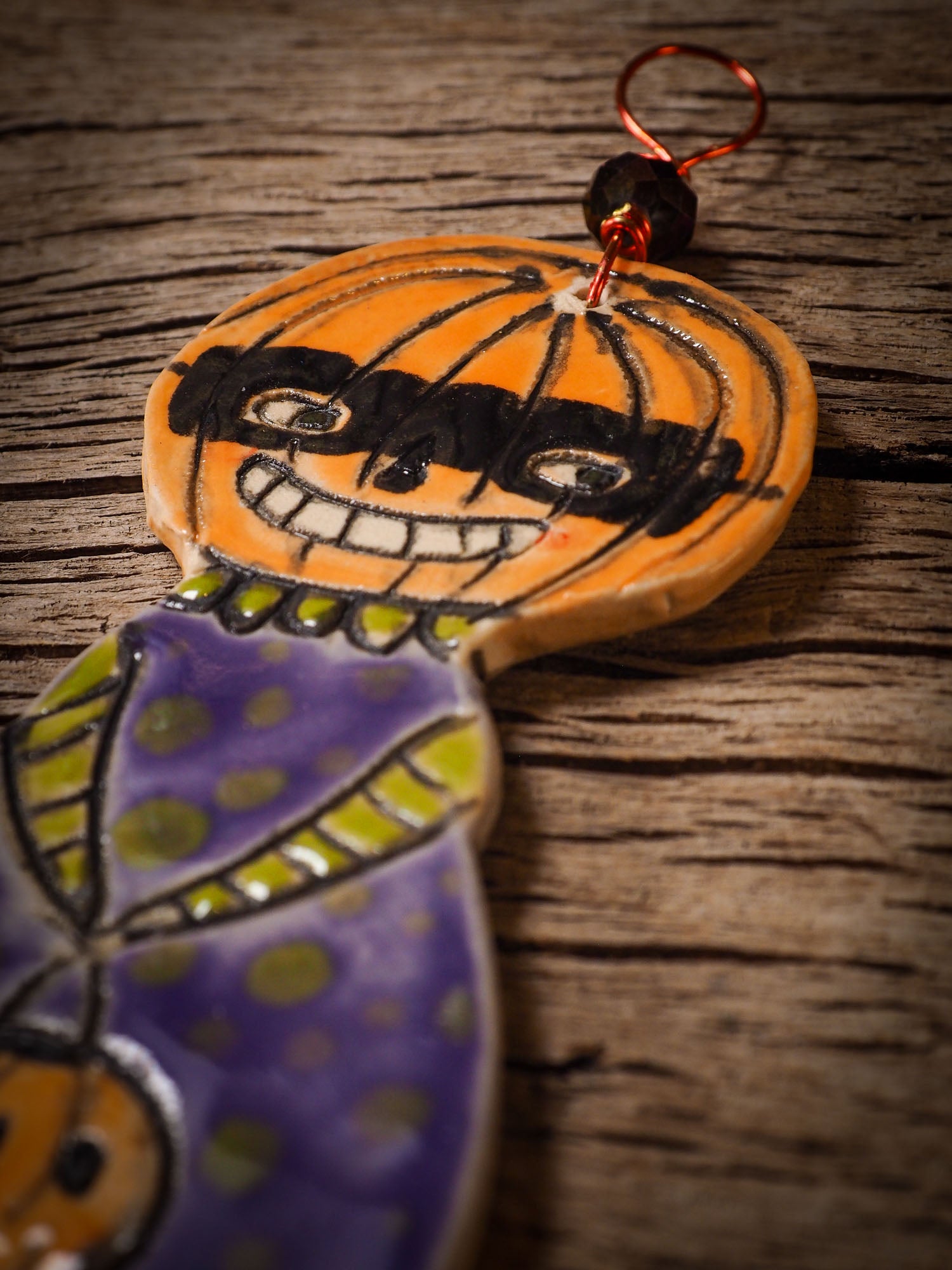 An original handmade Halloween ornament by Idania Salcido, Danita Art. Each ornament is hand carved with pumpkins, witches, cats, jack-o-lanterns and moons.  Made with fired glazed ceramics, this little witch, jack-o-lantern and cat is carved with delicate patterns that make each ornament a one of a kind work of art.