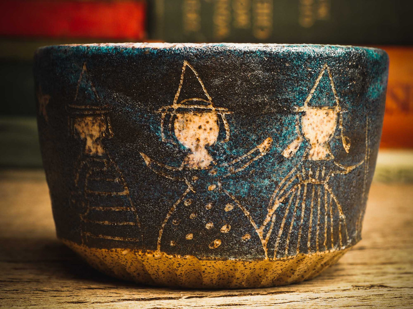 This little handmade ceramic halloween bowl by Idania Salcido Daita art has three witches carved on it, they are ready to cast a spell during a dark starry night, and you can see the magic stream from their wands in subtle bands of color across the deep, midnight blue sky. And of course, the moon and stars are there with them.
