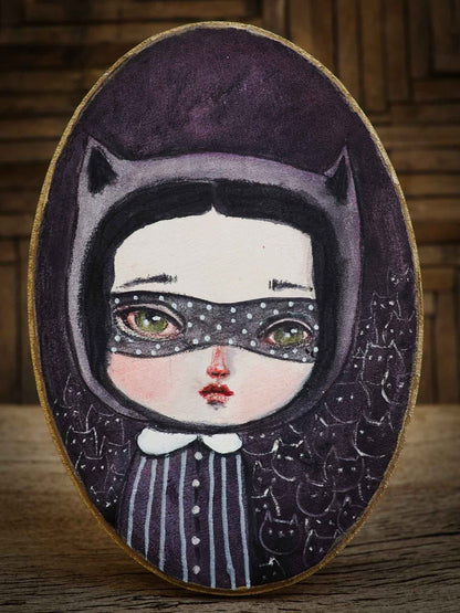 When I think of Cat Lady, I imagine a powerful woman with an army of cats at her disposal, so I painted this little girl in an oval wood canvas. I used watercolors to create an army of black cats with a mysterious ambiance where the cats are lookin right back at you, lurking in the shadows waiting to do her bidding.