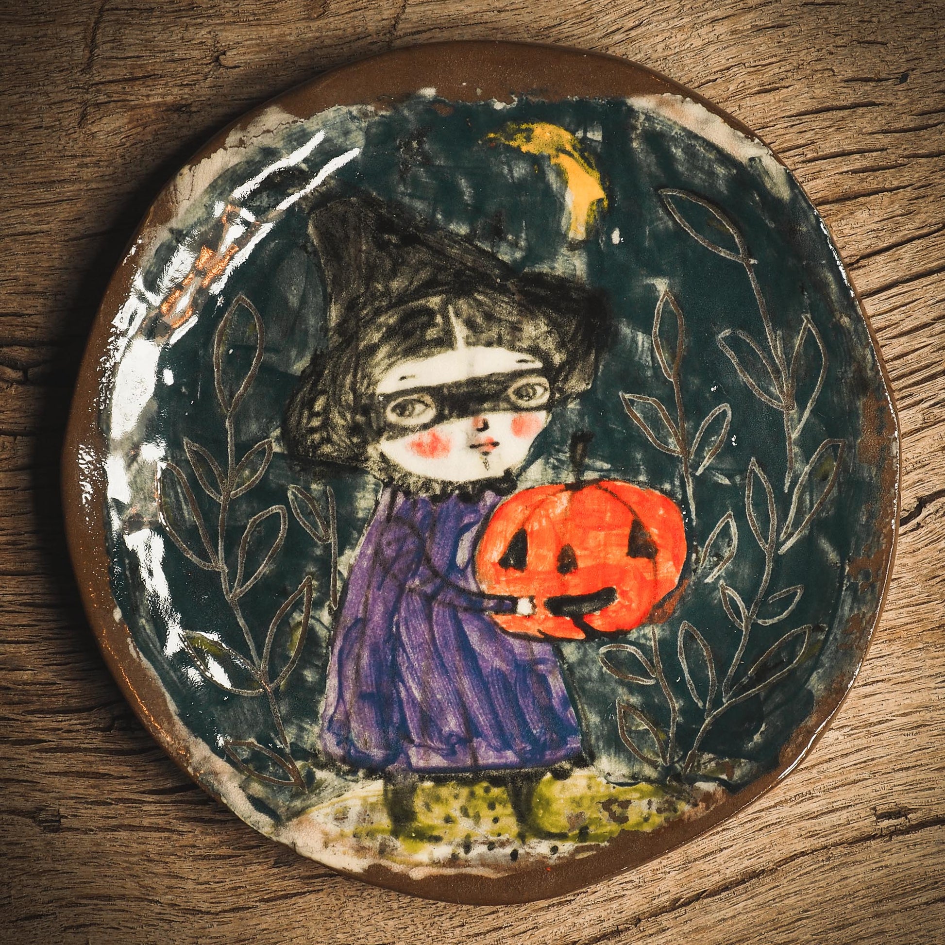 An original handmade Halloween ceramic dinner plate by Idania Salcido, Danita Art. Each plate is hand painted and glazed with pumpkins, witches, cats, jack-o-lanterns and moons. Made with fired glazed ceramics, this little witch, jack-o-lantern and cat plate is painted with delicate patterns that make it one of a kind artwork.