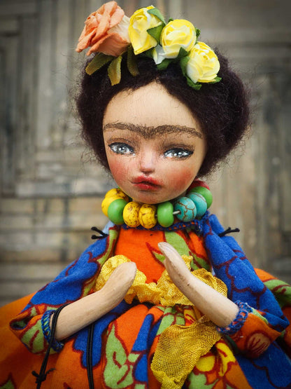 A beautiful handmade art doll by Danita, inspired by Mexican Folk art, Frida Kahlo and The Day Of the Dead. She wears a colorful native motif dress, an unmistakable unibrow, a colorful Dia De los Muertos Catrina skull mask and the signature amazing eyes of Danita Art.