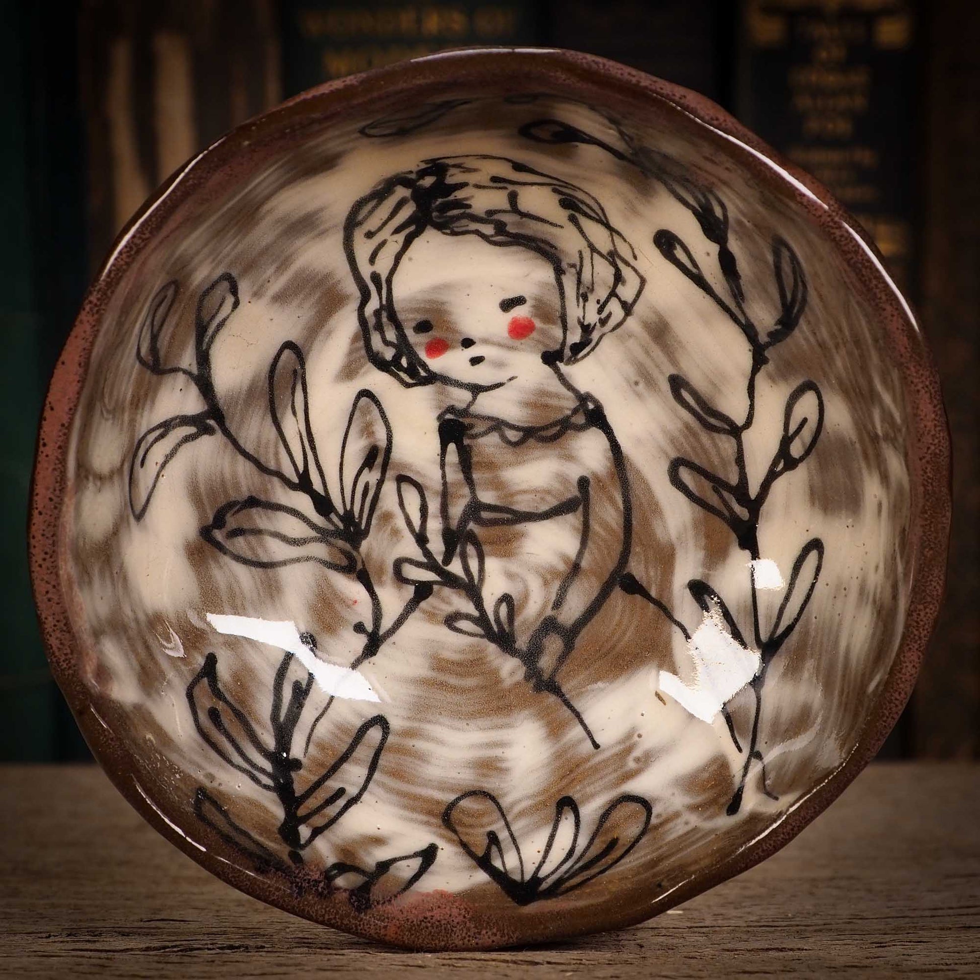 An original glazed ceramic food bowl by Idania Salcido, the artist behind Danita Art. Totally handmade in my studio, this is a unique piece that cannot be repeated. Food and drink safe, hand wash only. Brown earth tones and an ink drawing of a girl collecting plants on the inside.