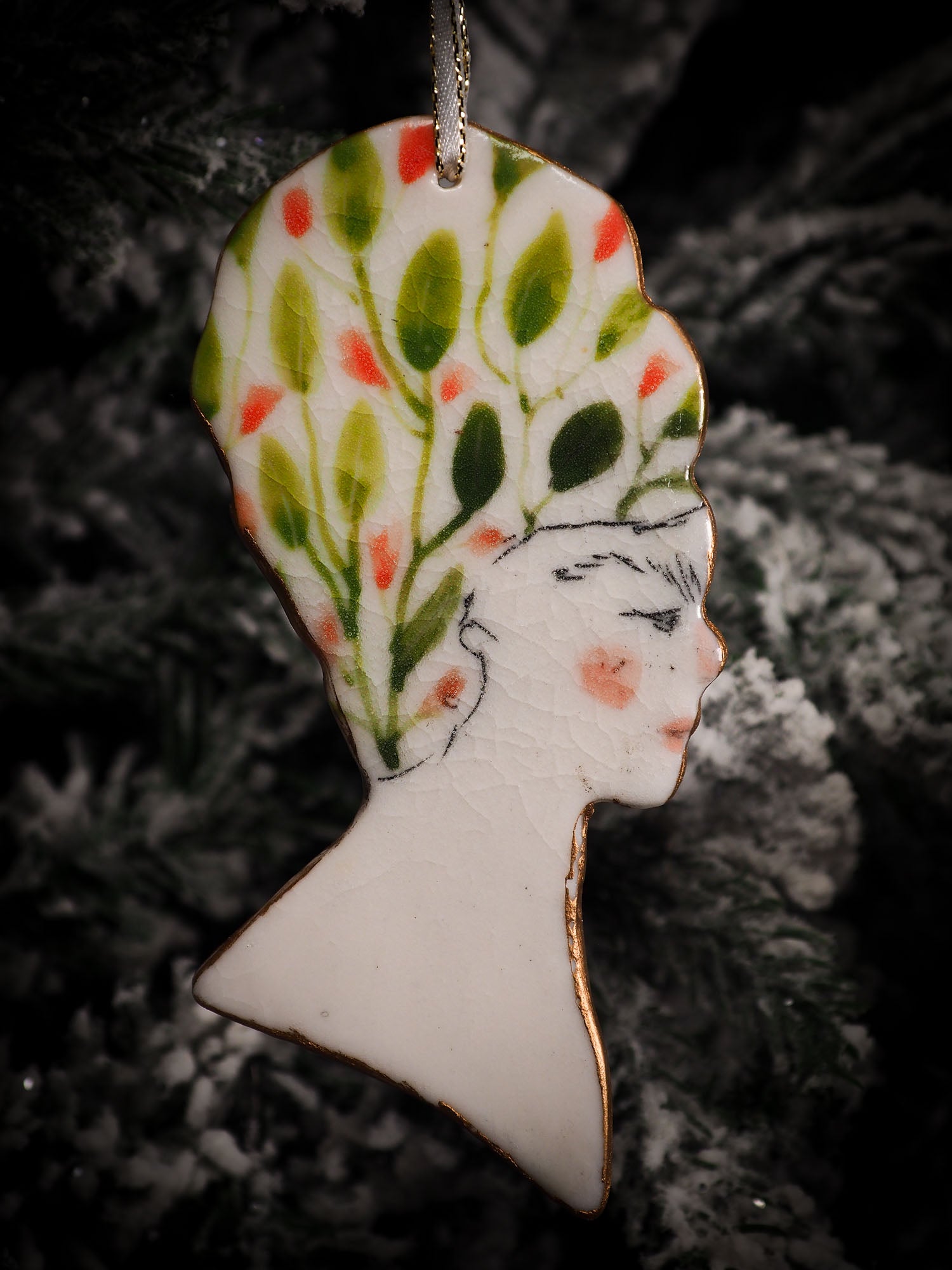 An original Christmas Holiday tree round glazed ceramic hanging ornament handmade by Idania Salcido, the artist behind Danita Art. Glazed carved sgraffito stoneware, hand painted and decorated, it is illustrated by hand with flowers, hearts, leaves, nature patterns and the face of Frida Kahlo.