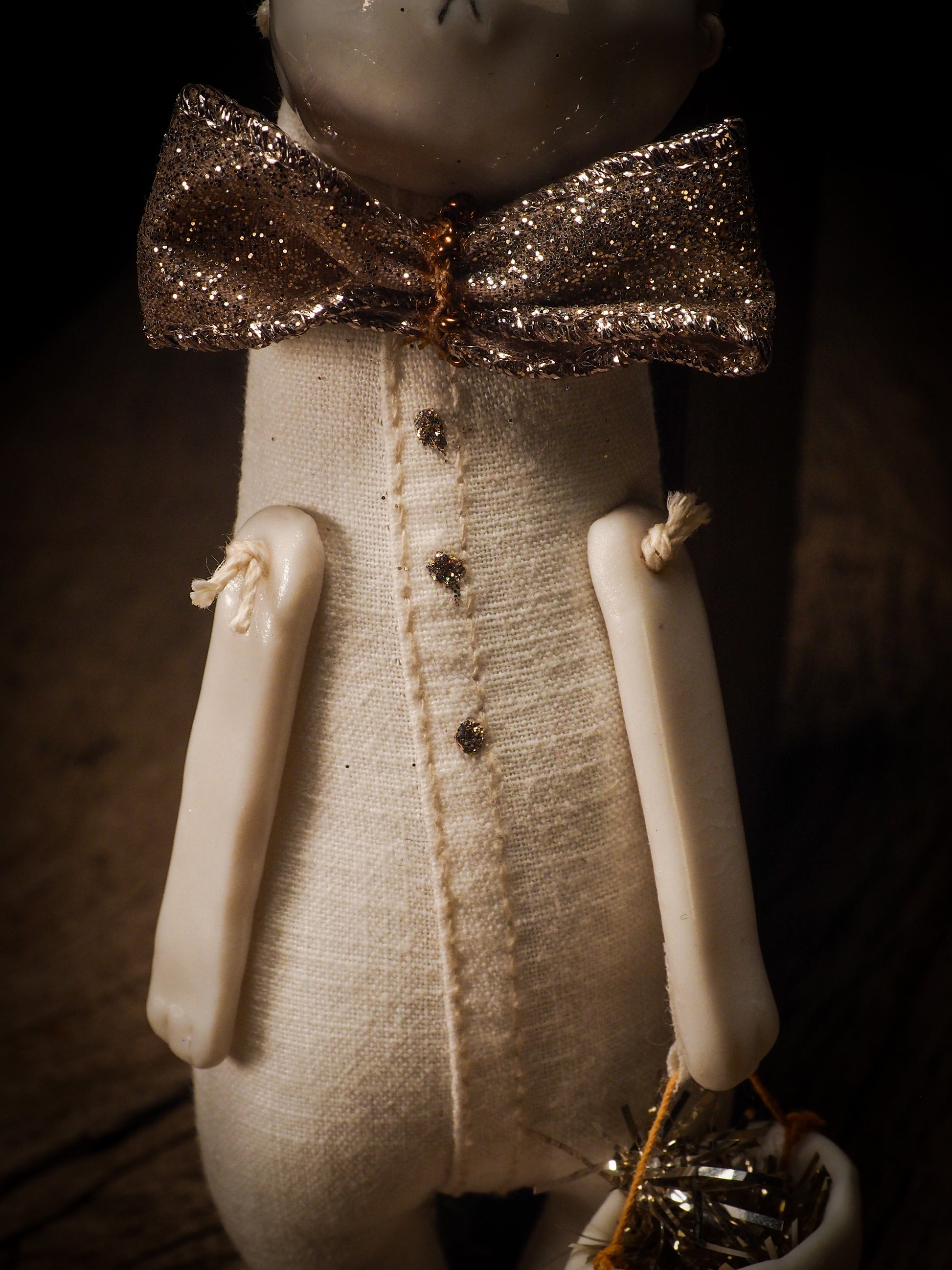 An adorable hand made porcelain and fabric fine art doll by Idania Salcido Danita Art. Perfect to hang as a delicate Christmas tree ornament, this fired ceramic mixed media artwork is unique. Each doll has a beautiful hand sculpted porcelain ceramic face and hand dyed fabric body with vintage accessories as home decor.
