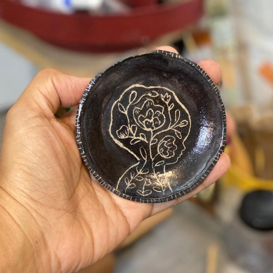 An adorable set of carved ceramic bowl and plate by Idania Salcido, the artist behind Danita Art. The bowl and matching plate are hand made, with carved engravings of the head of woman with flowers inside, and the outside of the bowl has a woman, a girl and a cat in a tree and flower garden.