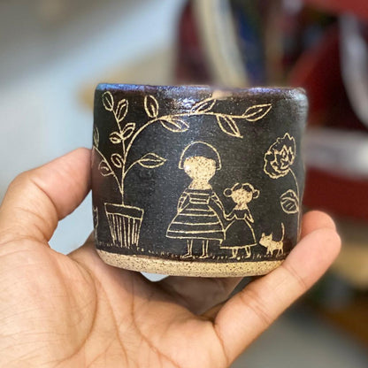 An adorable set of carved ceramic bowl and plate by Idania Salcido, the artist behind Danita Art. The bowl and matching plate are hand made, with carved engravings of the head of woman with flowers inside, and the outside of the bowl has a woman, a girl and a cat in a tree and flower garden.